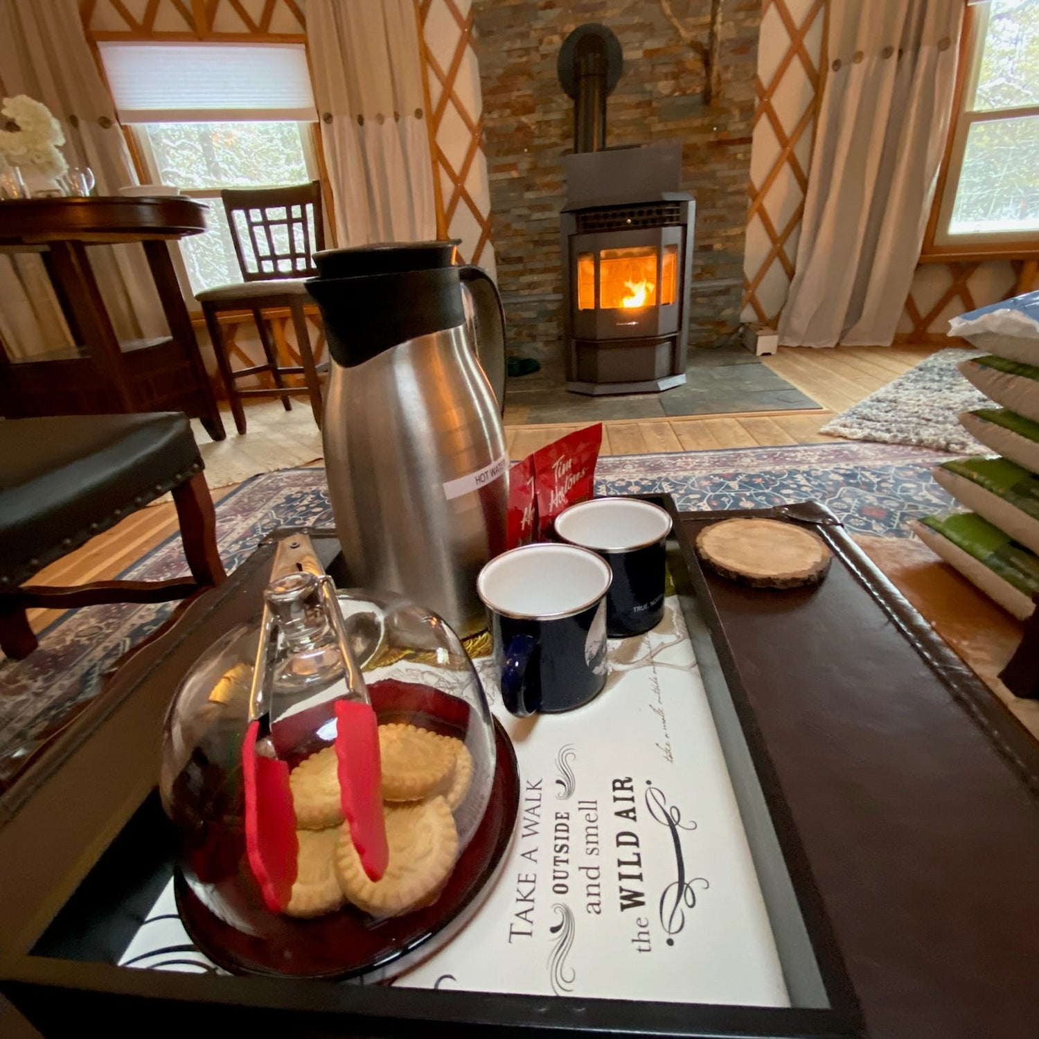 Tray with coffee and cookies in a cozy room with a fireplace